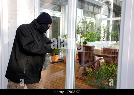 Burglar in a private house. Daylight burglary. Breaking into a house, an apartment to steel valuables. Stock Photo