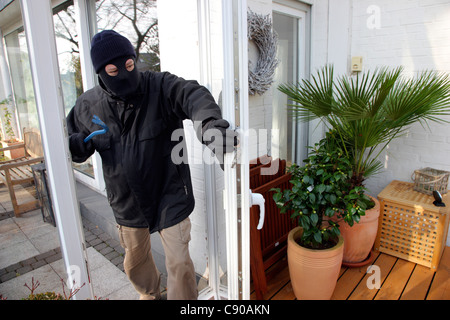 Burglar in a private house. Daylight burglary. Breaking into a house, an apartment to steel valuables. Stock Photo