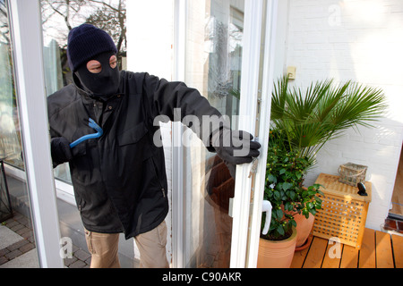 Burglar in a private house. Daylight burglary. Breaking into a house, an apartment to steel valuables. Stock Photo