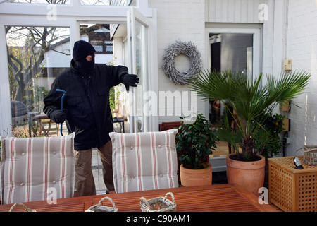 Burglar in a private house. Daylight burglary. Breaking into a house, an apartment to steel valuables. Stock Photo