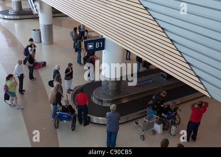 People waiting for luggage to arrive on baggage claim conveyor at San Jose Airport in California Stock Photo