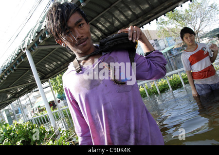 A man playing with centipede in floodwaters , Bangkok , Thailand Stock Photo