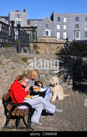 Two women sat on the promenade eating Fish and Chips, Tenby, Pembrokeshire, south-Wales, Wales, Great Britain Stock Photo