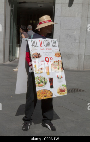 Man carrying advertising sandwich board of food menu' sign in Madrid Spain Stock Photo