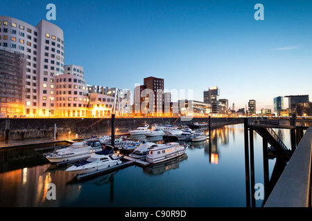 Buildings at Neuer Zollhof in the evening Frank O. Gehry Media Harbour at night Duesseldorf Duesseldorf North Rhine-Westphalia G Stock Photo