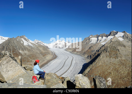 Woman looking towards glacier Grosser Aletschgletscher with Jungfrau, Moench, Eiger and Wannenhorn, Eggishorn, UNESCO World Heri Stock Photo