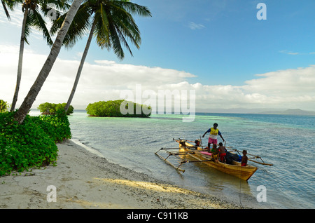 Papuan fishermen arrive at Paniki Island, Raja Ampat islands near West Papua, Indonesia in the coral triangle, Pacific Ocean. Stock Photo