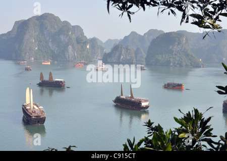 Traditional two masted Vietnamese junks are a popular way for visitors to see Ha Long Bay and the landscape of limestone rock Stock Photo