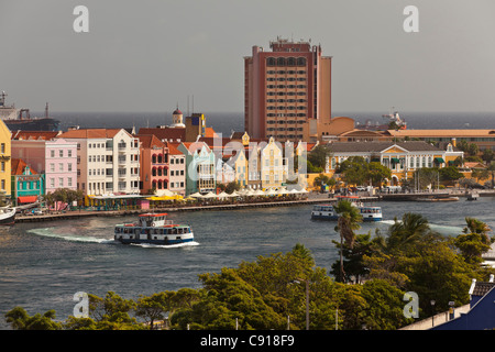 Curacao, Caribbean island, Willemstad. Historic houses on waterfront. Ferry boats crossing St Annabaai. Stock Photo