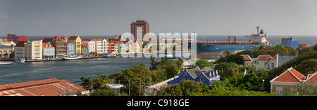 Curacao, Caribbean island, Willemstad. Historic houses on waterfront. Oil tanker and ferry boat crossing St Annabaai. Stock Photo