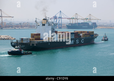 large container ship 'MSC DIEGO' entering Valencia harbour Spain with tugs assisting Stock Photo