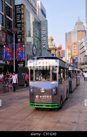 Nanjing Road is one of the world's busiest shopping streets. It is pedestrianised and there are small trolley buses running up Stock Photo