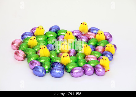 Little fake chickens on colored easter chocolate eggs Stock Photo