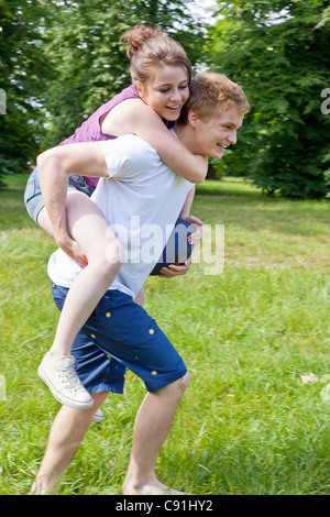 Boy carrying girlfriend piggyback Stock Photo