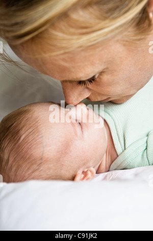 Mother touching noses with infant Stock Photo