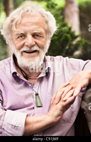 Older man sitting with hands folded Stock Photo