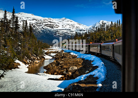 White Pass & Yukon Railroad on an early Summer excursion with snow still on the ground, Skagway, Southeast Alaska Stock Photo