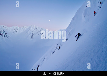 Skier and his spotter skiing steep powder on the north side of Kickstep Mountain, Turnagain Pass, Kenai Mountains, Alaska. MR Stock Photo