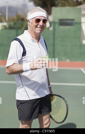 Older man drinking lemonade on court Stock Photo