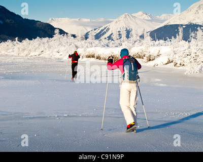 Couple Nordic ice skating on the frozen Placer River, Kenai Mountains, Southcentral Alaska, Winter Stock Photo