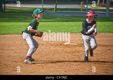 Youth baseball player takes lead off base. Stock Photo