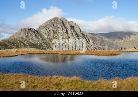 View across Llyn Y Caseg-fraith to Tryfan mountain and walkers in Snowdonia National Park. Conwy, North Wales, UK, Britain
