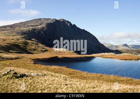 View across Llyn Y Caseg-fraith lake to Glyder Fach with Bristly ridge in side profile in Snowdonia National Park mountains. North Wales UK Britain