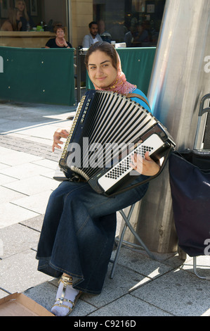 Busker playing an accordion in Queen Street, Cardiff, South Wales, UK Stock Photo