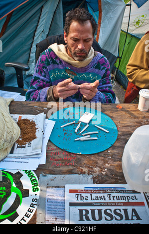 Occupy Wall Street OWS protest demonstration, Zuccotti Park, Manhattan, NYC Rolling cigarettes by hand. Stock Photo