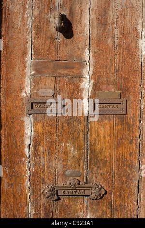 Old wooden doors with traditional letterboxes and ornate door knockers are commonplace in Porto Portugal. Stock Photo