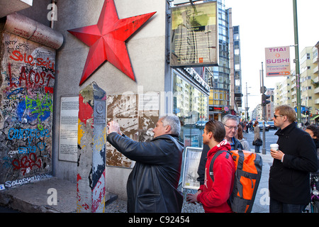 Tourist on the former Gdr east-west german border at Friedrichstrasse in front of Checkpoint charlie house, Berlin, Germany Stock Photo