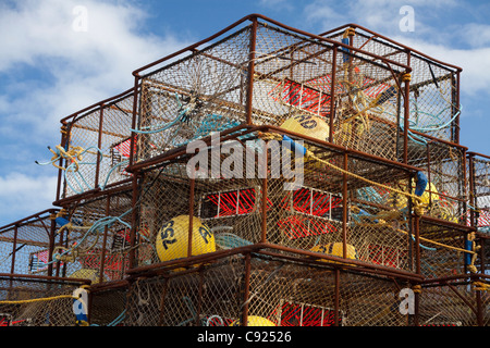 Stack of crab pots rigged with orange triggers for Pacific cod fishery and stored near Pier One in the City of Kodiak, Alaska Stock Photo