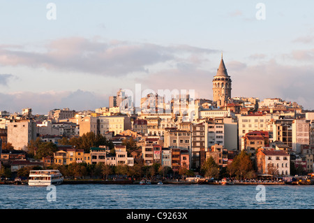 Late afternoon sun shining on the Galata skyline, viewed from Eminonu, Istanbul, Turkey Stock Photo
