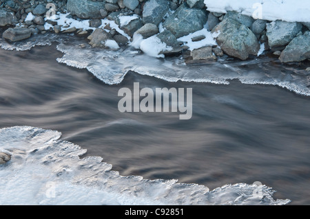 Ice lines the stream flowing from Westchester Lagoon into Cook Inlet, Anchorage, Southcentral Alaska, Winter Stock Photo