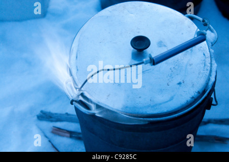 Mehtanol-fueled flame heats up a pan of snow to melt water for a dog team, Gates of the Arctic National Park & Preserve, Alaska Stock Photo