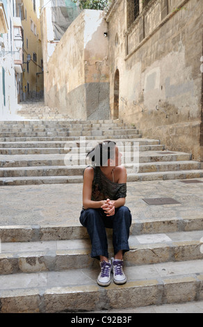 Young woman sitting on stairs Stock Photo