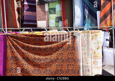 Spain, Alicante Province, Xabia, coloured quilts for sale at market stall Stock Photo