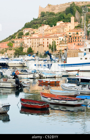 Italy, Tuscany, Monte Argentario, Porto Ercole, boats in harbour with old town and Forte Stella (fort) in background Stock Photo