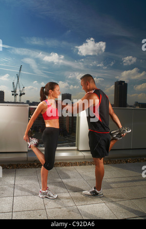 Athletes exercising together on rooftop Stock Photo