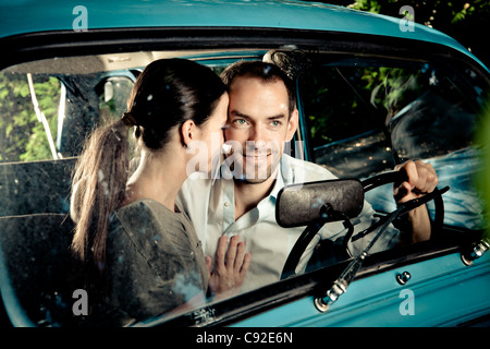 Kissing couple driving car at night Stock Photo