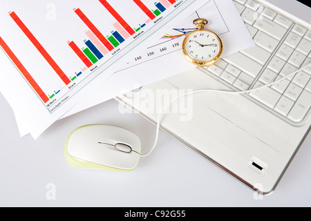 Pocket watch with information Chart on laptop keyboard, directly above Stock Photo