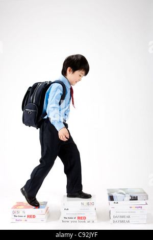 Full length of boy carrying books in corridor at school Stock Photo - Alamy