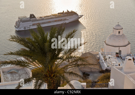 Santorini - cruise ship MSC Armonia moored off Fira, seen from clifftop café bar. Stock Photo