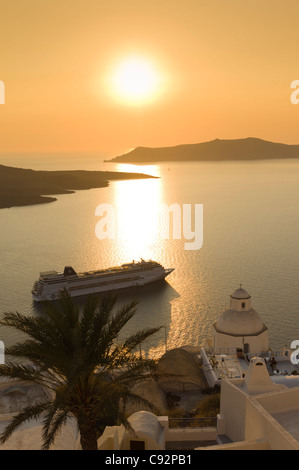 Santorini - sunset from Fira over the islands of the volcanic caldera. With cruise ship MSC Armonia. Stock Photo
