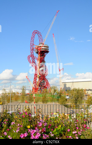 Floral display along Greenway path part of London 2012 Olympic construction site cranes work in progress on ArcelorMittal Orbit tower Stratford UK Stock Photo