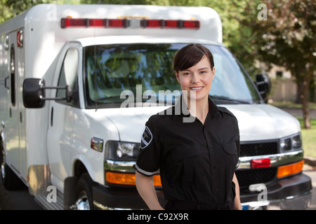 Portrait of attractive paramedic standing in front of ambulance Stock Photo