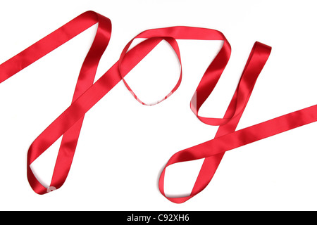 Joy word written in red ribbon on white background Stock Photo