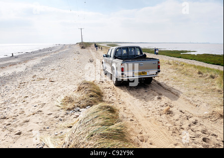 Sea storm coastal erosion at Spurn Head, Yorkshire east coast England. 4 wheel drive car on damaged narrowest point of sand spit Stock Photo