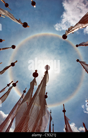 A very unusual full circle rainbow phenomenon surrounded by lungdhar Buddhist prayer flags. Stock Photo