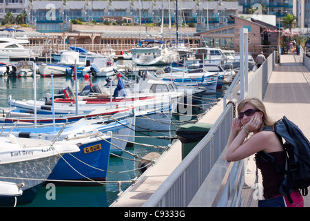 Portrait of young woman and boats in Ocean Village, Gibraltar. Stock Photo